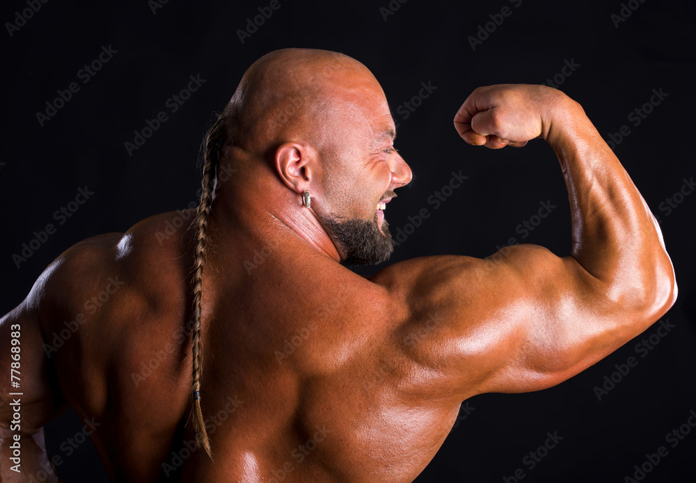 Bodybuilder demonstrating muscles of the back and arms Bodybuilder demonstrating muscles of the back and arms