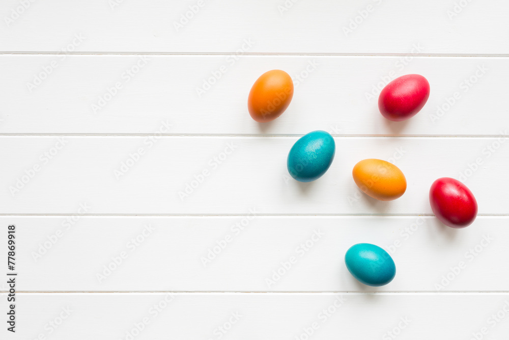 Easter eggs on white wooden background, top view