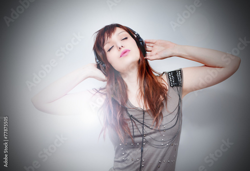 Canvastavla Hermosa mujer joven escuchando música con auriculares