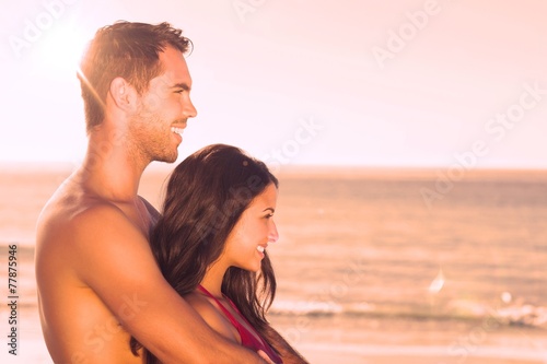 Happy couple in swimsuit hugging while looking at the water © WavebreakmediaMicro