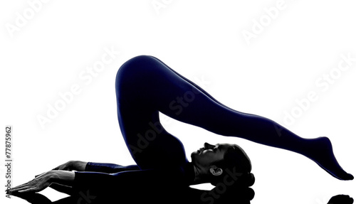 woman exercising halasana plow pose yoga silhouette photo