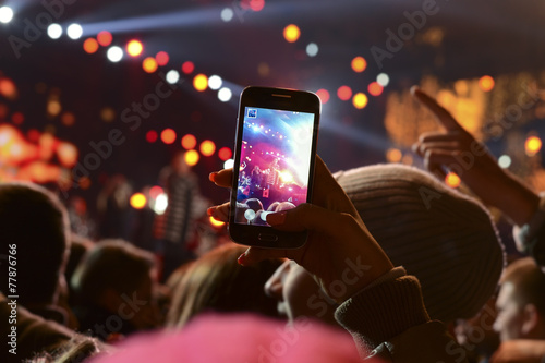 People holding their smartphones and photographing concert