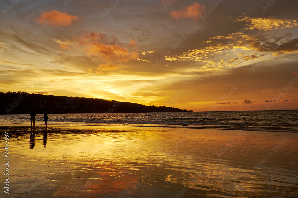 silhouettes of couples on the beach in sunset