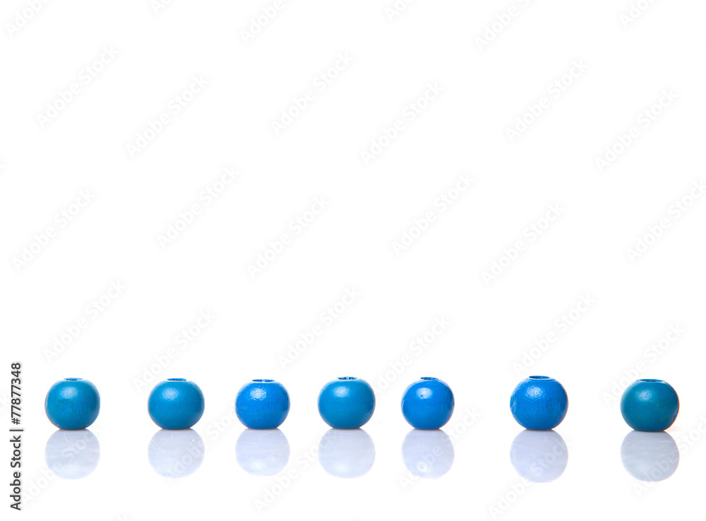 Blue round wooden beads over white background
