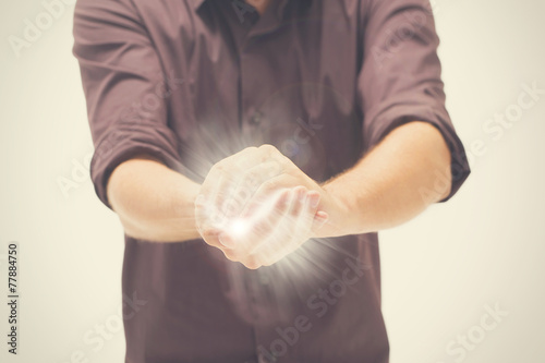 Man trying to hold the light between hands photo