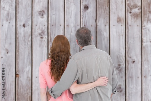 Composite image of casual couple standing arm around