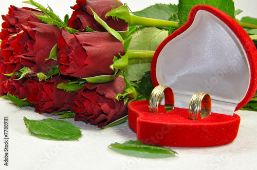 Rose and wedding rings isolated on white background