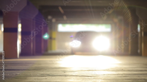 Sports car rides in the parking lot and shining lights into lens