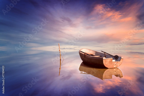 Lonely boat and amazing sunset at the sea photo