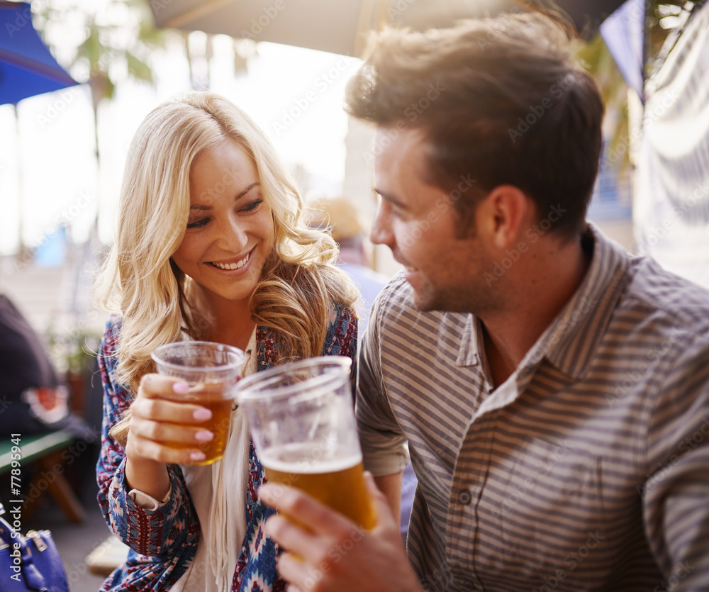 romantic couple drinking beer in plastic cups at outdoor bar romantic couple drinking beer in plastic cups at outdoor bar