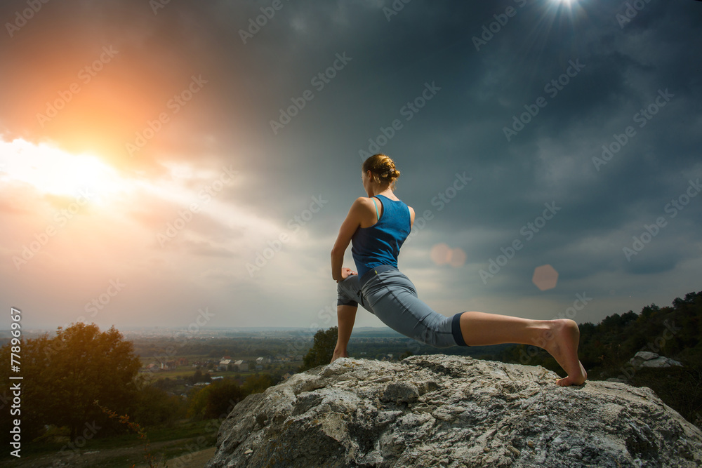 Woman doing yoga against the setting sun Woman doing yoga against the setting sun
