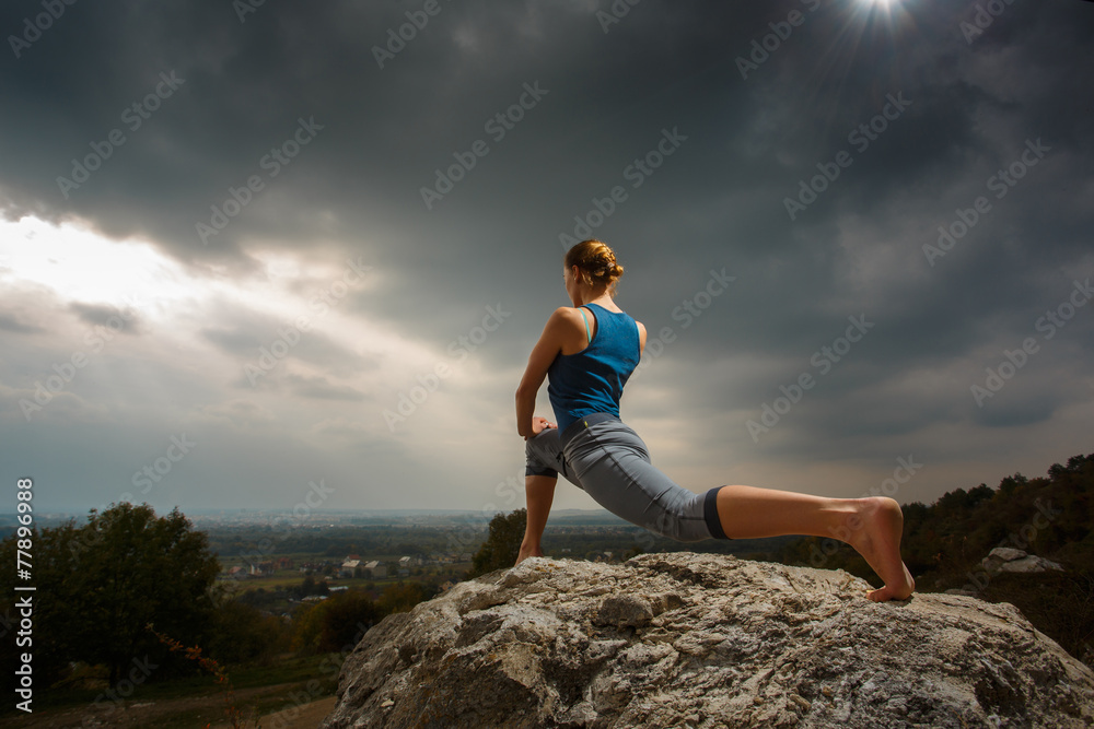 Woman doing yoga against the setting sun Woman doing yoga against the setting sun