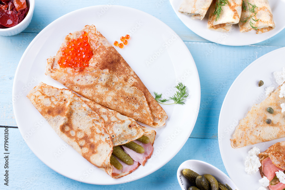 Thin pancakes, crepes with red caviar, salmon, pickled cucumbers Thin pancakes, crepes with red caviar, salmon, pickled cucumbers