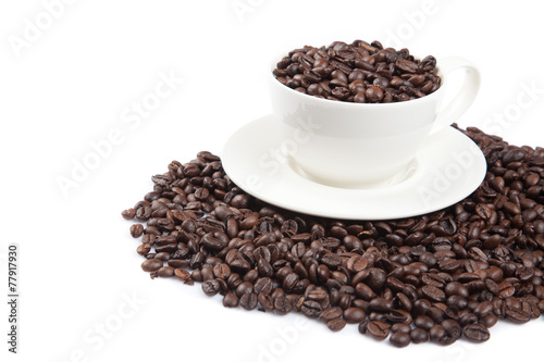 Roasted coffee beans with a cup