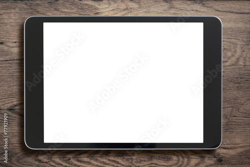 Black tablet pc or ipad on old wood background