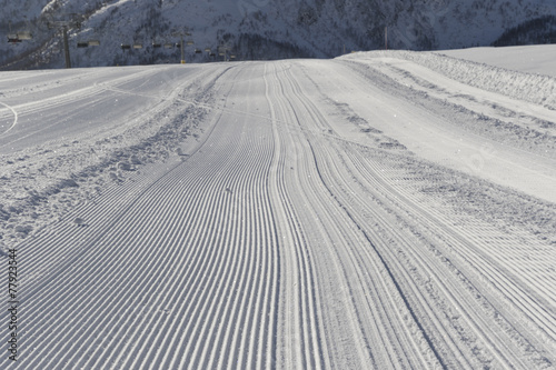 Fresh snow groomer tracks on a ski piste