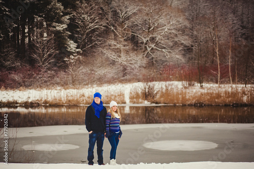 cute couple standing on the shore of a frozen river