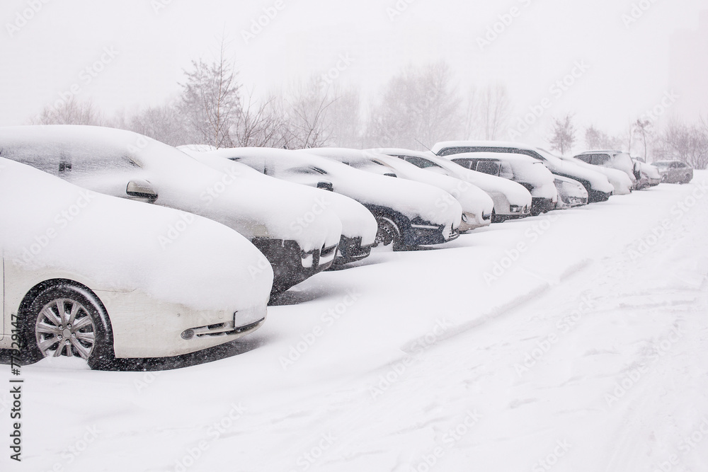 Snow-covered cars during a winter blizzard