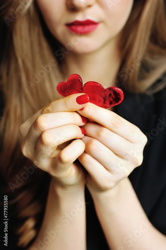 Two candy hearts in women's hands