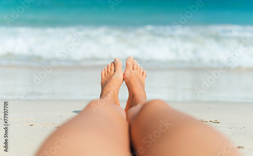 Woman lying on the beach. Legs.