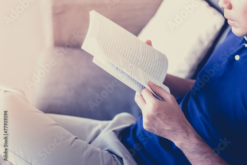 A man reading book while sitting on the couch - vintage & retro