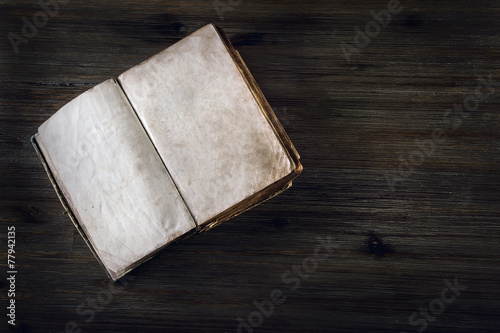 Old open book without text on a wooden table