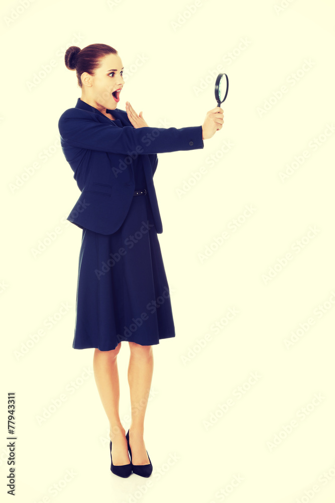 Business woman looking into a magnifying glass Business woman looking into a magnifying glass