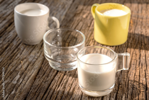 Fresh glass of milk on old wood background photo