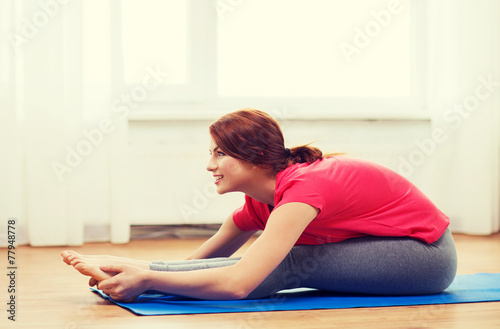 smiling teenage girl streching on floor at home