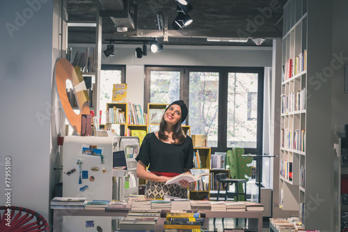 Beautiful young brunette posing in a bookstore