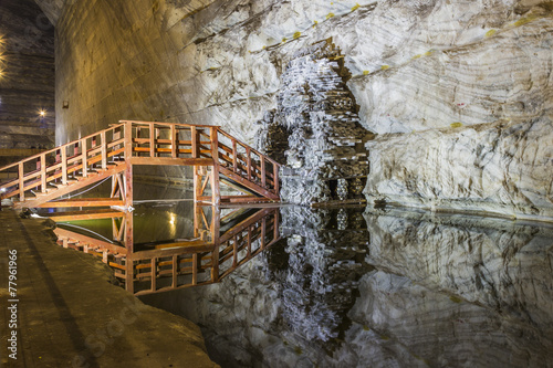 Wooden bridge reflexion in underground salt mine lake photo