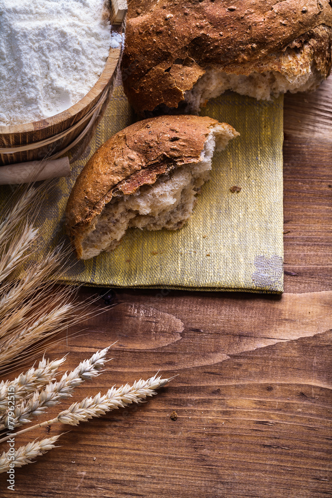 slice of bread with wheat ears and flour in bucket on old wooden slice of bread with wheat ears and flour in bucket on old wooden