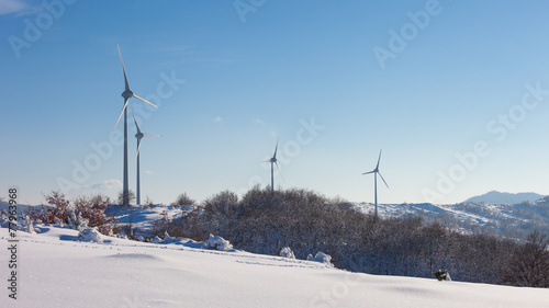 Typical windmill or aerogenerator of aeolian energy on snowy lan © PriceM