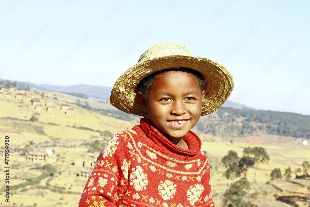 Smiling african boy with hat on head, poverty in Madagascar