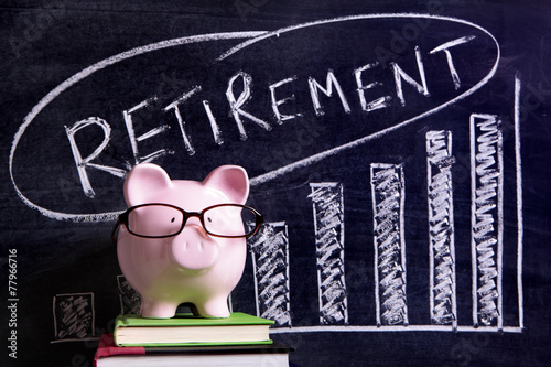 Piggy Bank piggybank wearing glasses with retirement savings plan message and chart written on a blackboard or chalk board photo