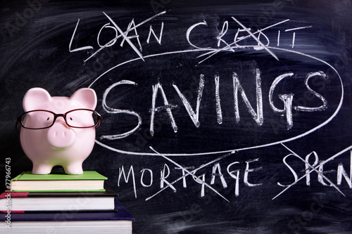 Piggy Bank piggybank wearing glasses with savings plan message written on a blackboard or chalk board photo