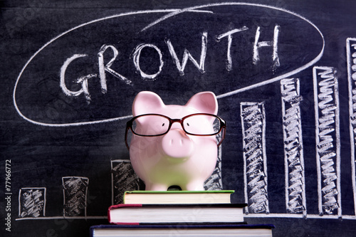 Piggy Bank piggybank wearing glasses with retirement savings growth plan message and chart written on a blackboard or chalk board photo