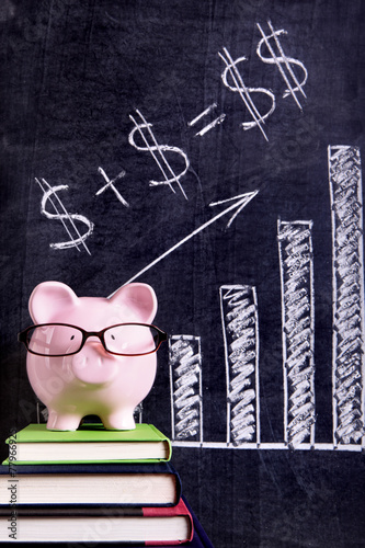 Piggy Bank piggybank wearing glasses with savings plan message and chart formula written on a blackboard or chalk board photo