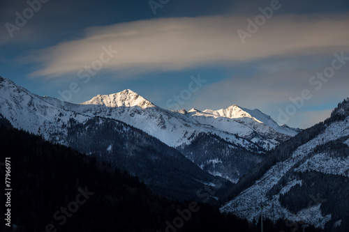 landscape of sun shining on mountain top covered by snow