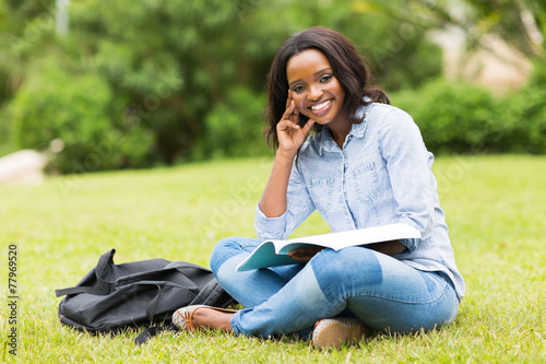 young african college girl sitting on grass