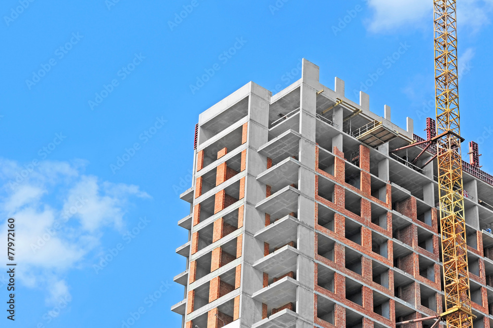 Fototapeta premium Crane and building construction site against blue sky