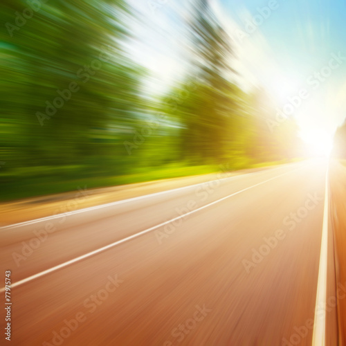 Country road in motion blur and sunlight. © Elena Volkova