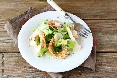 Salad with shrimps, lettuce and parmesan on a plate