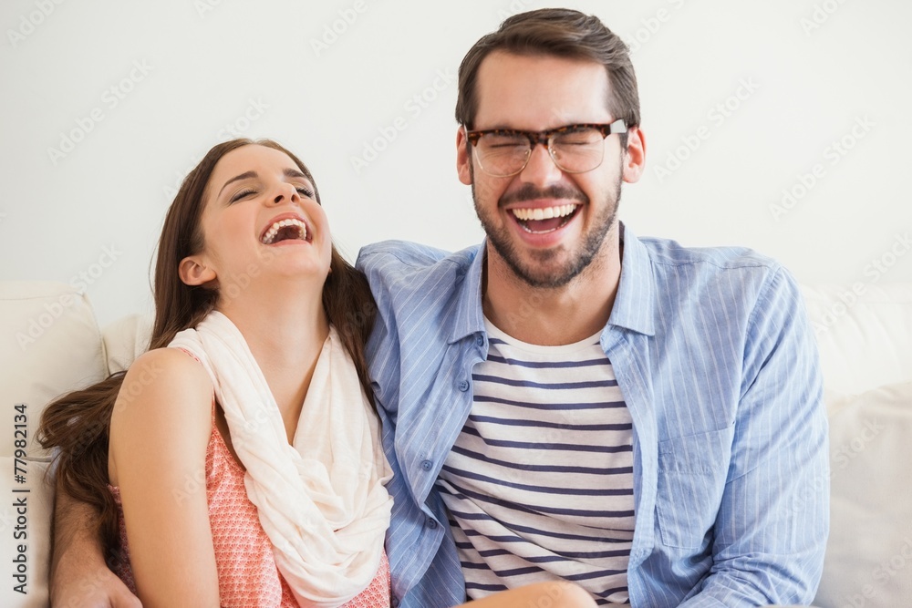 Young couple smiling at camera on couch Young couple smiling at camera on couch