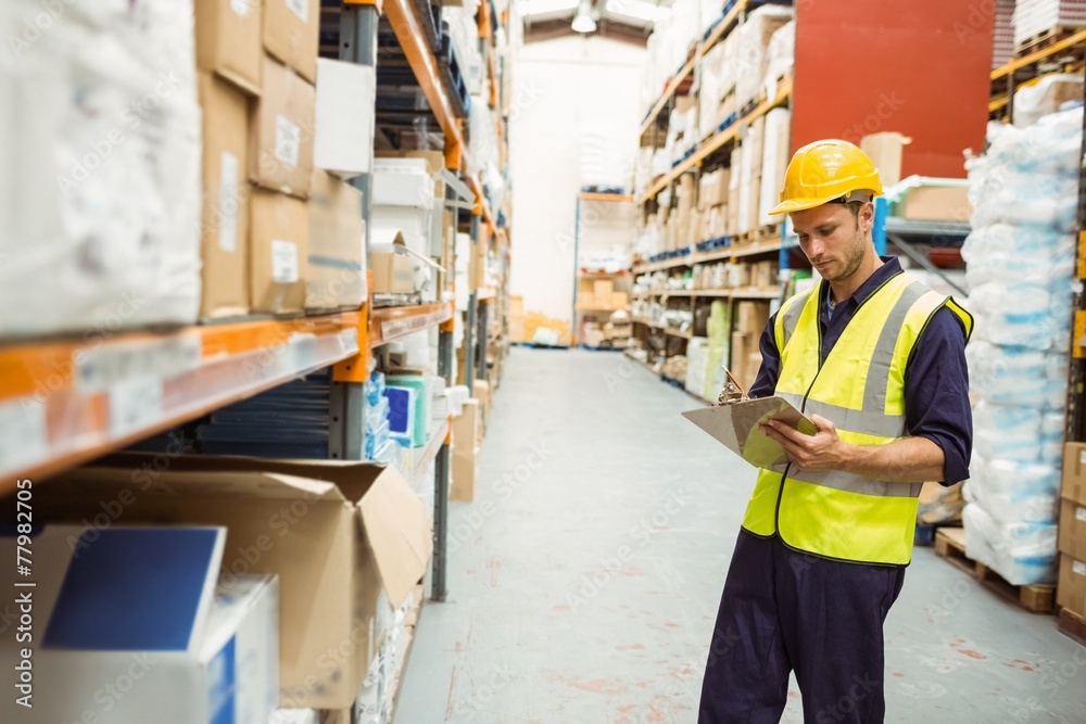 Focused warehouse worker with clipboard Focused warehouse worker with clipboard