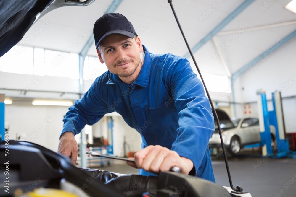 Mechanic examining under hood of car Mechanic examining under hood of car