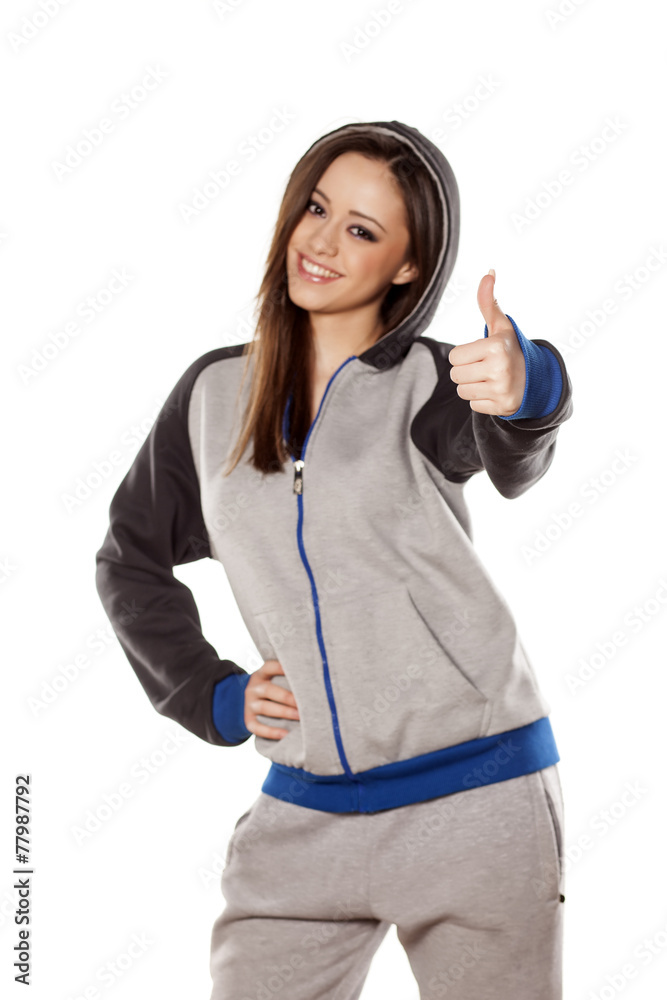 happy young woman in track suits showing thumb up happy young woman in track suits showing thumb up