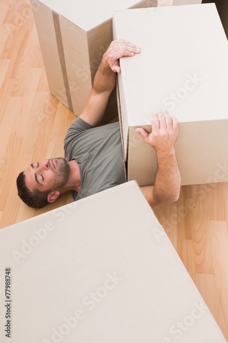 man sleeping with moving boxes at home