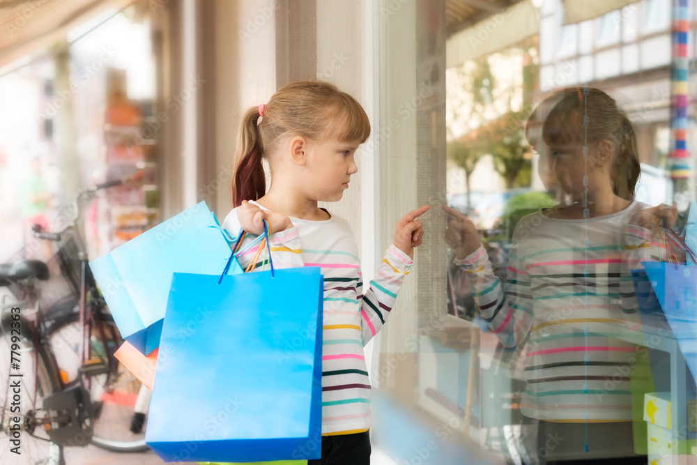 Little girl looking at shop window Little girl looking at shop window