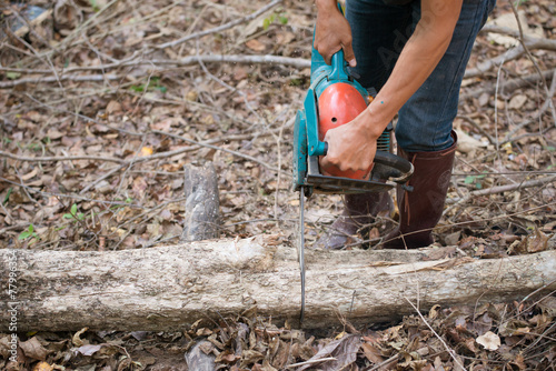  Man cutting the wood with chainsaw